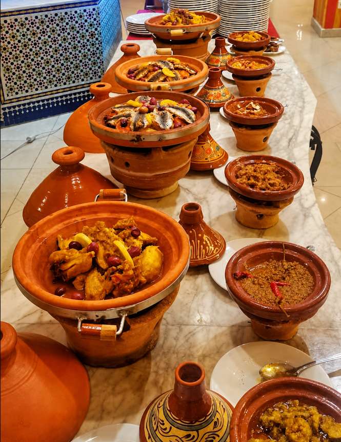 أطباق طاجين مغربية على طاولة بوفيه رخامية في مطعم الفندق
